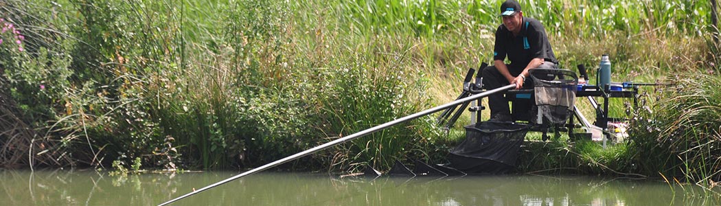 Vissen aan de waterkant met een vaste hengel
